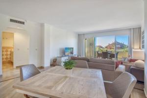 a living room with a couch and a table at modern apartment by the sea.(Marbella) in Marbella