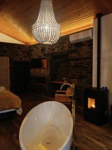 a bath tub in a room with a chandelier at Casa do Romezal in Peso da Régua