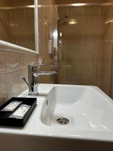 a bathroom sink with a mirror and a remote control at PFA Hotel Viareggio in Viareggio