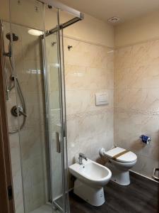 y baño con ducha, aseo y lavamanos. en PFA Hotel Viareggio, en Viareggio