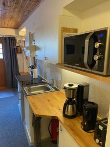 a kitchen with a sink and a microwave at Huddinge Studio with Private Entrance in Huddinge