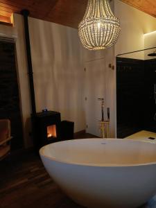 uma grande banheira branca num quarto com um lustre em Casa do Romezal em Peso da Régua