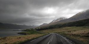 a road in the middle of a valley with mountains at Saxa Guesthouse in Stöðvarfjörður