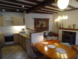 une cuisine avec une table en bois et une salle à manger dans l'établissement Le Pelerine, à Sauveterre