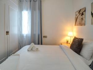 Una cama blanca con una toalla encima. en Soleil by Hello Homes Sitges, en Sitges