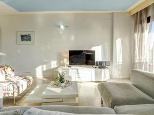 sala de estar con sofá y TV en Soleil by Hello Homes Sitges, en Sitges