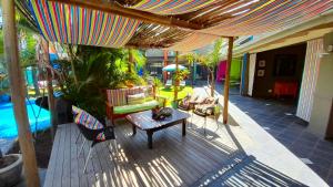 eine Terrasse mit einem Tisch und Stühlen unter einem Sonnenschirm in der Unterkunft Elephant Springs in Bela-Bela