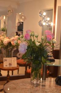 un jarrón lleno de rosas rosas sentadas en una mesa en Hotel Graupner, en Bamberg