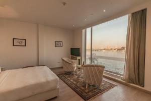 a bedroom with a bed and a large window at Riverside Hotel in Cairo