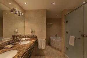 Riverside Hotel في القاهرة: حمام به مغسلتين وحوض استحمام ومرآة