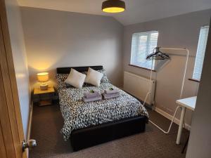 a bedroom with a bed with two pillows on it at Modern 3 bedroom home in Guildford. Sleeps 8 in Guildford