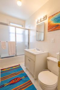 een badkamer met een toilet, een wastafel en een spiegel bij New Listing!! Bright Bohemian Stay in Laramie