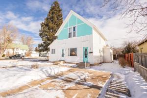 een wit huis met een blauw dak in de sneeuw bij New Listing!! Bright Bohemian Stay in Laramie