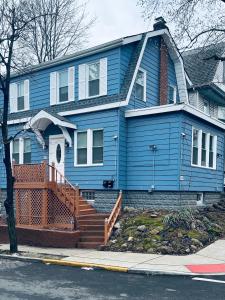 a blue house with a staircase in front of it at Cozy Room in Private Home in Irvington