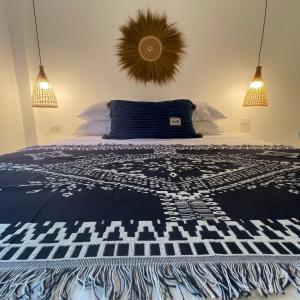 a bedroom with a bed with a black and white blanket at Acqualanta House in Ko Lanta