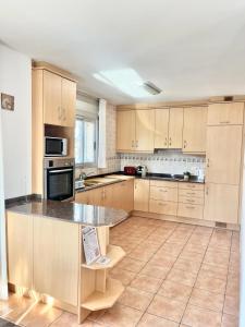 a large kitchen with wooden cabinets and a counter top at La Palmera in L'Ampolla