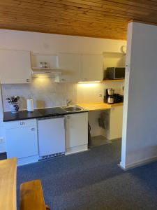 cocina con armarios blancos y encimera en Huddinge Studio with Private Entrance, en Huddinge