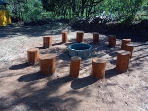 un grupo de muñones de madera en un campo de tierra en Coorg Derala Camping Tent House en Madikeri