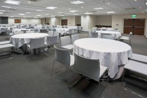 uma sala de conferências com mesas brancas e cadeiras brancas em City Express Plus by Marriott Monterrey Nuevo Sur em Monterrey