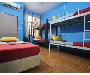 a room with three bunk beds in a room at ShopLot Hostel Pangkor in Pasir Bogak