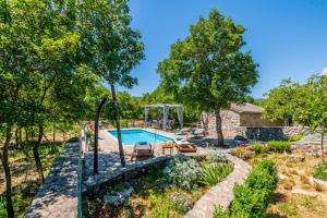 uma imagem de uma piscina num jardim em Villa Ognjistar in the hinterland of Makarska Riviera em Zmijavci