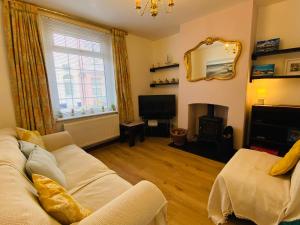 a living room with a white couch and a fireplace at Green Sails House in Weymouth