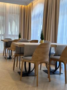 a row of tables and chairs in a room with windows at Hotel Antoni in Tomaszów Lubelski