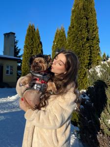 a woman holding a dog in her arms in the snow at Вілла ЮРАН Східниця in Skhidnitsa