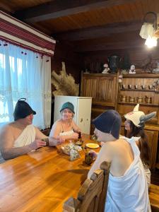 a group of people sitting around a wooden table at Вілла ЮРАН Східниця in Skhidnitsa