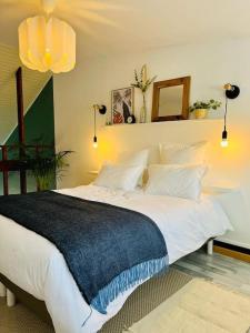 ein Schlafzimmer mit einem großen Bett mit einer blauen Decke darauf in der Unterkunft Joli appartement en duplex, parking privé Hortillonage in Amiens