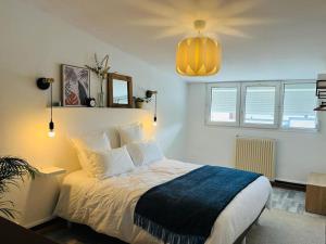 ein Schlafzimmer mit einem großen Bett mit einer blauen Decke in der Unterkunft Joli appartement en duplex, parking privé Hortillonage in Amiens