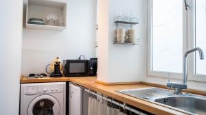eine Küche mit einer Spüle und einer Waschmaschine in der Unterkunft L'hôtel de ville - Joli petit T2 en centre-ville in Poitiers