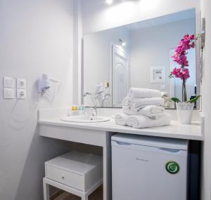 a white bathroom with a sink and a mirror at Cavo D'oro All Inclusive Resort in Kalamaki