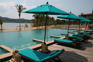 a pool with blue lounge chairs and umbrellas at Koh Chang Appartment 2 bedrooms in Ban Bang Bao