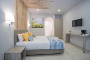a bedroom with a bed and a table and a tv at Cavo D'oro All Inclusive Resort in Kalamaki