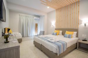 a bedroom with two beds and a television in it at Cavo Doro in Kalamaki
