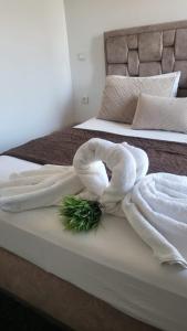 een bed met twee handdoeken en een groene plant erop bij Appart Hotel Tanger Paname in Tanger