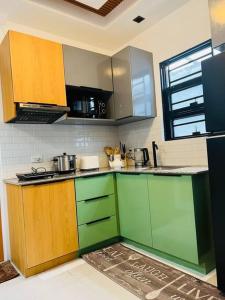 a kitchen with green and brown cabinets in a room at Modern Home and Stylish Design in Ibaba