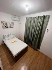 ein kleines Schlafzimmer mit einem Bett und einem Fenster in der Unterkunft Modern Home and Stylish Design in Ibaba