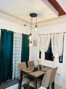 einen Esstisch und Stühle mit blauen Vorhängen in der Unterkunft Modern Home and Stylish Design in Ibaba