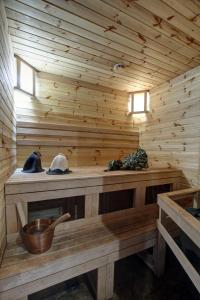 a wooden sauna with two windows and a bowl at Villa Alvīne Family Apart-Hotel in Jūrmala