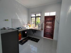 a kitchen with a counter and a sink and a window at Tok Mek Homestay in Setiu