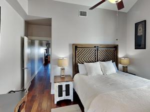 a bedroom with a large bed and a ceiling fan at Beach Please in Port Aransas