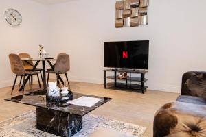 sala de estar con TV, mesa y sillas en Monthly Discounts: Luxury House Near Durham City en Durham