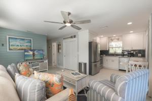 a living room with two couches and a kitchen at Turtle Tracks East in Sanibel