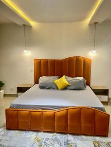 a large bed with a wooden headboard in a room at AL_MUBARAK ,APARTMENT in Ikeja