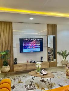 a living room with a flat screen tv on a wall at AL_MUBARAK ,APARTMENT in Ikeja