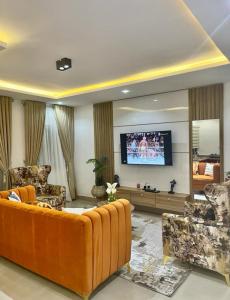 a living room with a couch and a flat screen tv at AL_MUBARAK ,APARTMENT in Ikeja