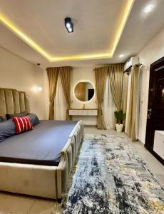 a bedroom with a large bed and a rug at AL_MUBARAK ,APARTMENT in Ikeja