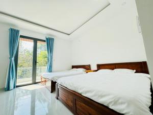 two beds in a bedroom with a window at Lava Rock Viet Nam Lodge in Cat Tien
